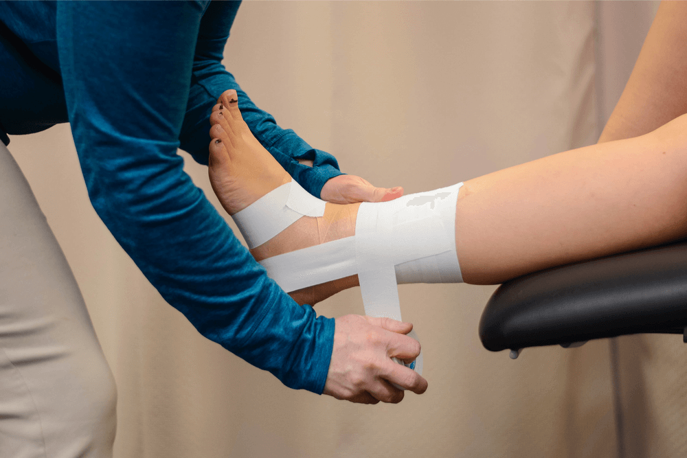 Close-up of an ankle taped using athletic tape for support and stability after injury