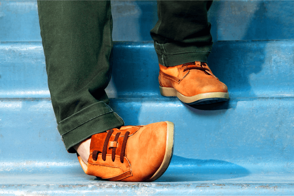 Close-up of legs in sneakers descending stairs, depicting an ankle sprain or misstep