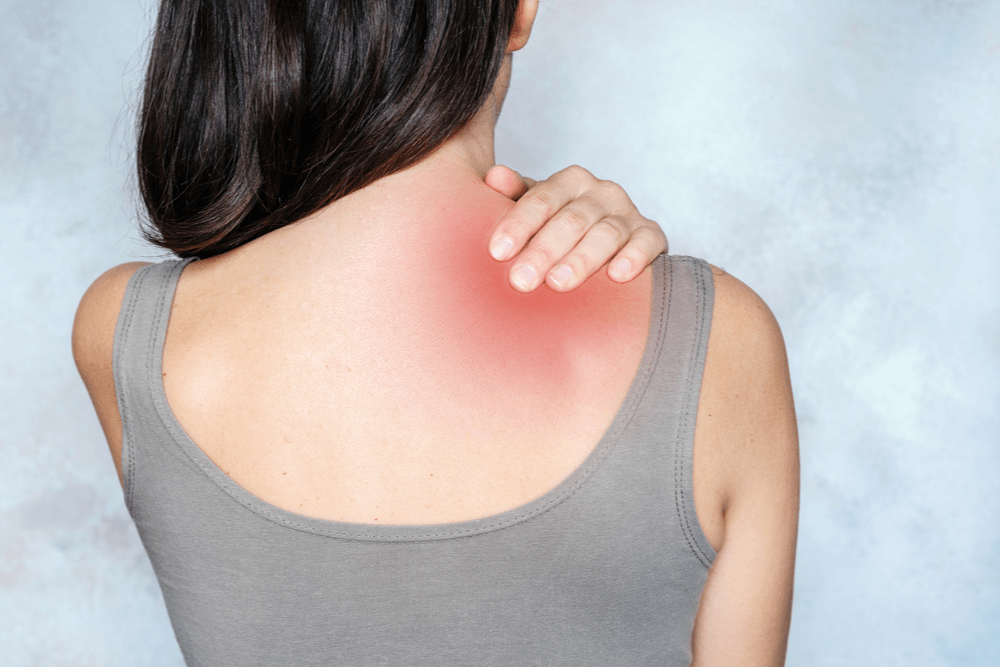 Woman massaging her shoulder and neck to relieve pain points